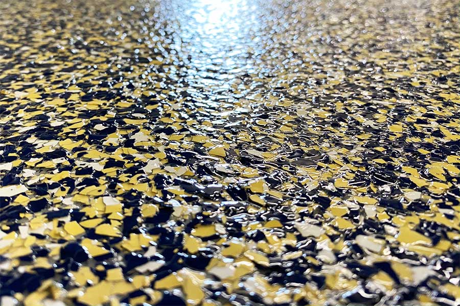 Flake flooring is a resilient flooring solution that involves embedding decorative flakes or chips into a resinous base during installation, resulting in a durable and visually appealing surface.